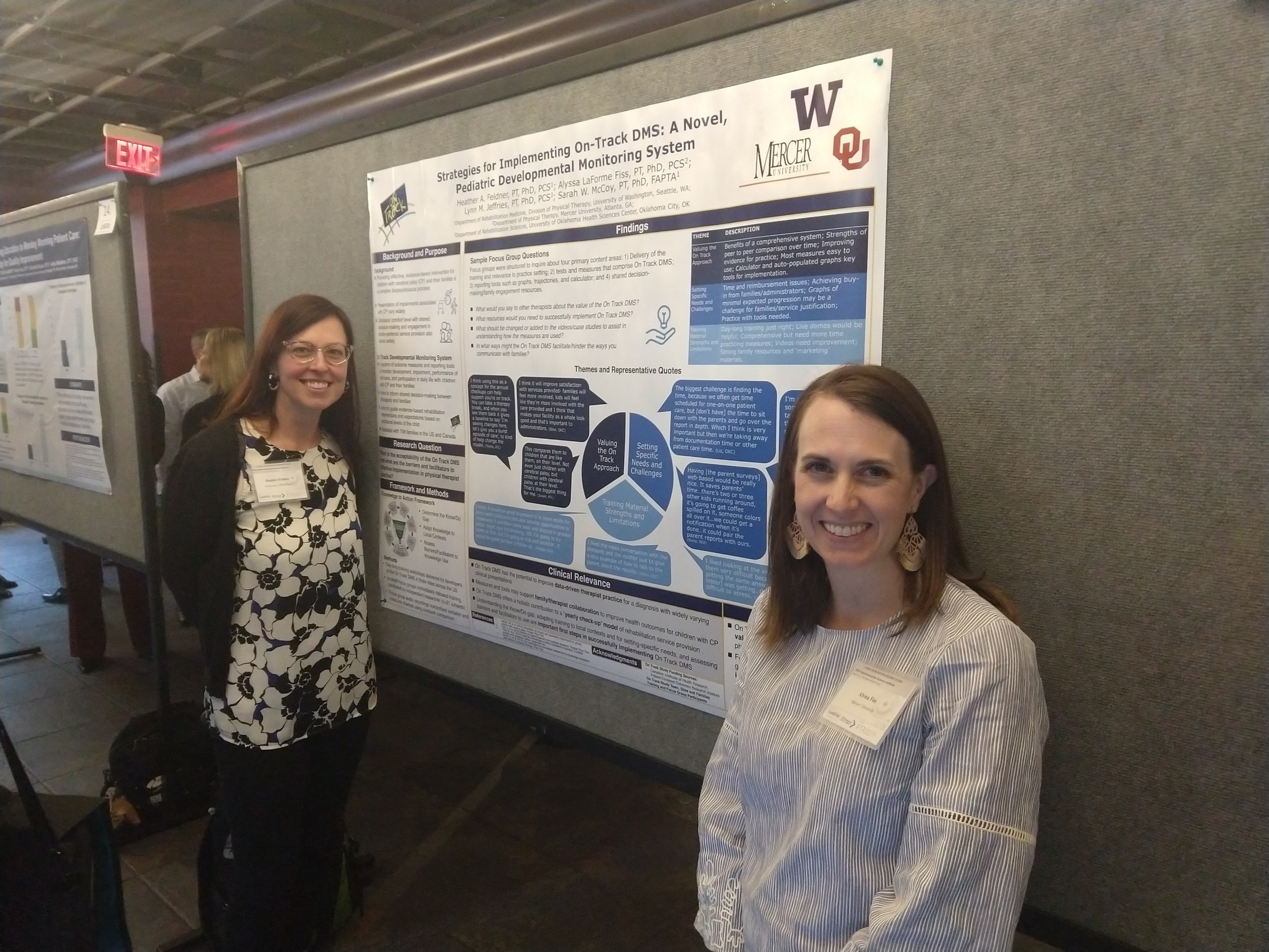 Two researchers, Heather Feldner and Alyssa LaForme Fiss, from Mercer University, stand in front of their research poster on implementation science.