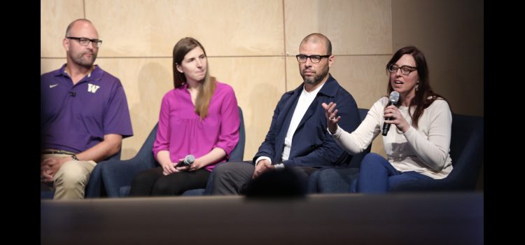 Microsoft IdeaGen Conference 2019 A panel of four presenters on a stage, from left to right is Jacob Wobbrock, Kat Steele, Oscar Murillo, and Heather Feldner, who is speaking into the microphone